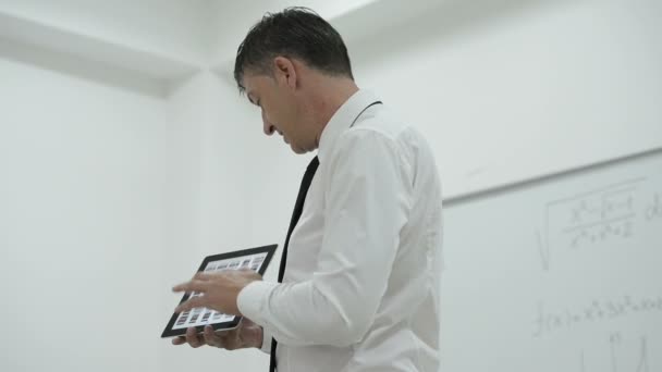 Teacher presenting lesson to students with tablet computer in modern school interior — Stock Video