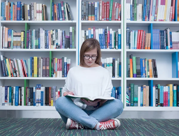 Studente ragazza lettura libro in biblioteca — Foto Stock