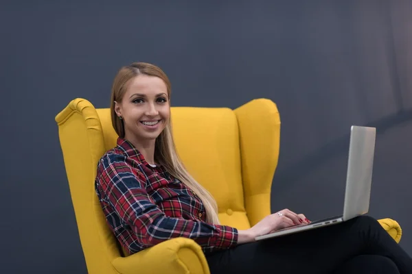 Negócio de inicialização, mulher trabalhando no laptop e sentado no amarelo — Fotografia de Stock