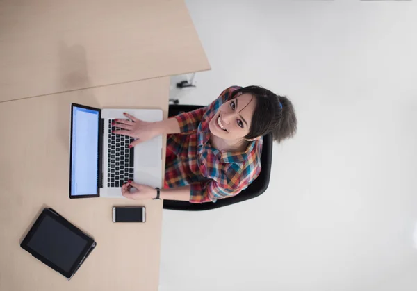 Вид сверху на молодую деловую женщину, работающую на ноутбуке — стоковое фото