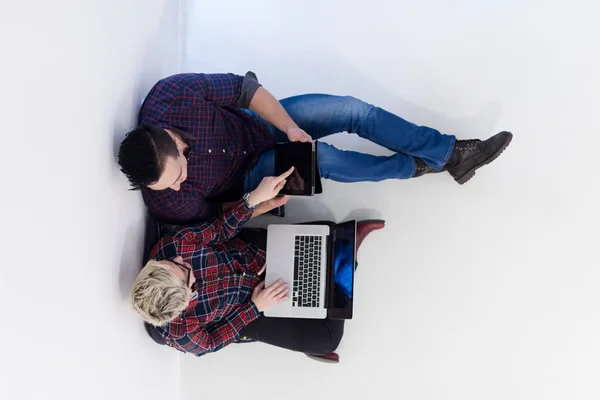 Vue de dessus du couple travaillant sur l'ordinateur portable au bureau de démarrage — Photo