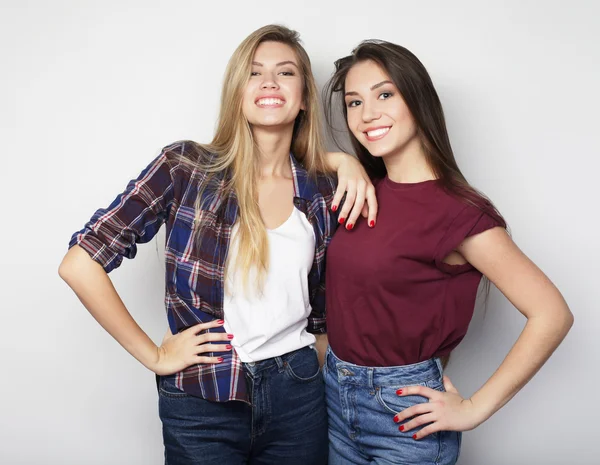 Dos amigas jóvenes de pie juntas y divirtiéndose. — Foto de Stock