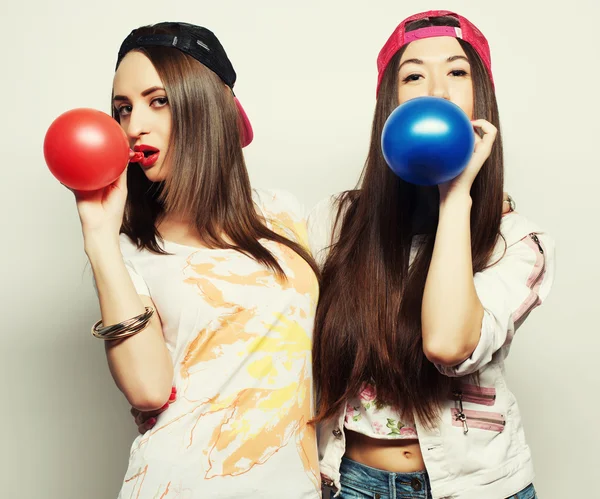 Hipster lányok mosolyogva és a gazdaság színes léggömbök — Stock Fotó