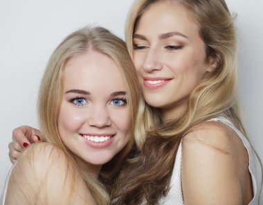 İki genç kız arkadaş birlikte durup eğleniyorlar..