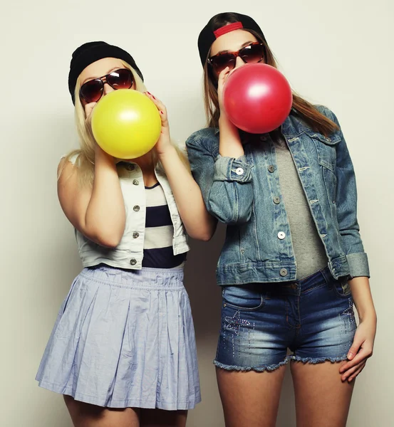 Hipster-Mädchen lächeln und halten bunte Luftballons in der Hand — Stockfoto