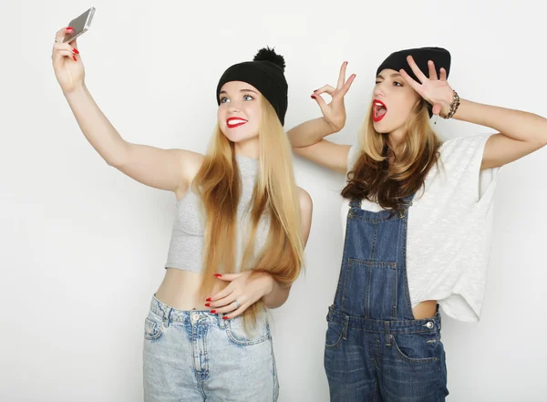 Две молодые женщины делают селфи с помощью мобильного телефона — стоковое фото