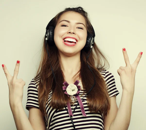 Mladá šťastná žena se sluchátky poslech hudby — Stock fotografie