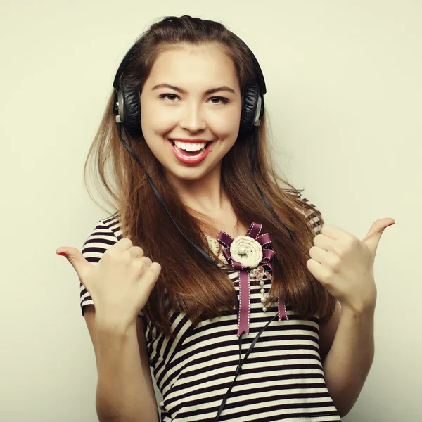 Jovem mulher feliz com fones de ouvido ouvindo música — Fotografia de Stock