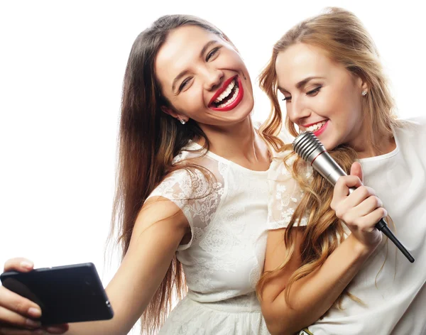 Chicas de belleza con un micrófono cantando y hacer selfie — Foto de Stock