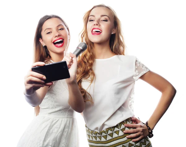 Chicas de belleza con un micrófono cantando y hacer selfie — Foto de Stock