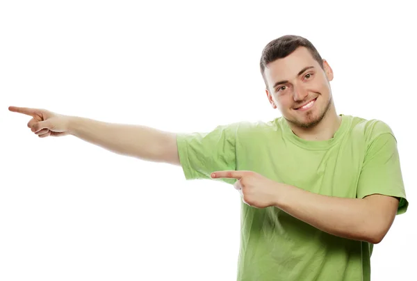 Young smiling happy man shows something — Stock Photo, Image