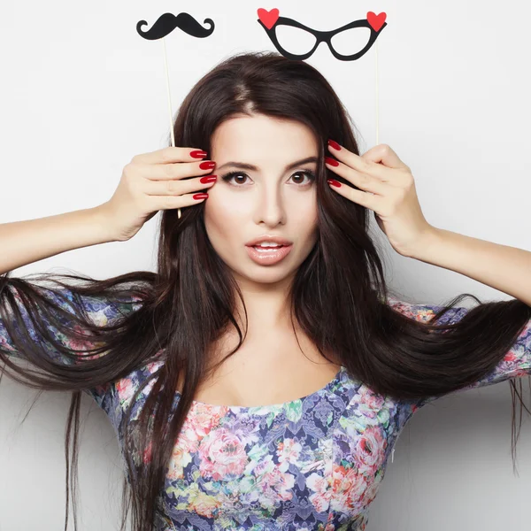 Imagen de fiesta. Jovencita juguetona sosteniendo unas gafas de fiesta . — Foto de Stock