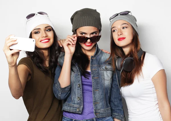 Three happy teenage girls with smartphone taking selfie — Stock Photo, Image