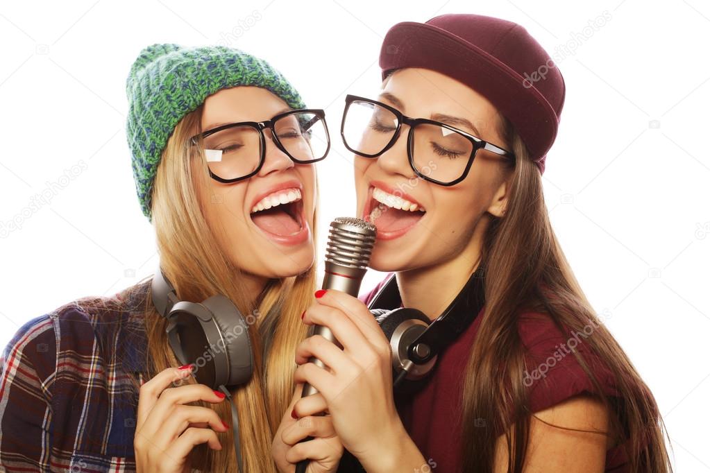 two beauty hipster girls with a microphone singing