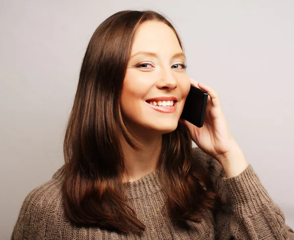 Woman using a mobile phone isolated on a white background — Stock Photo, Image