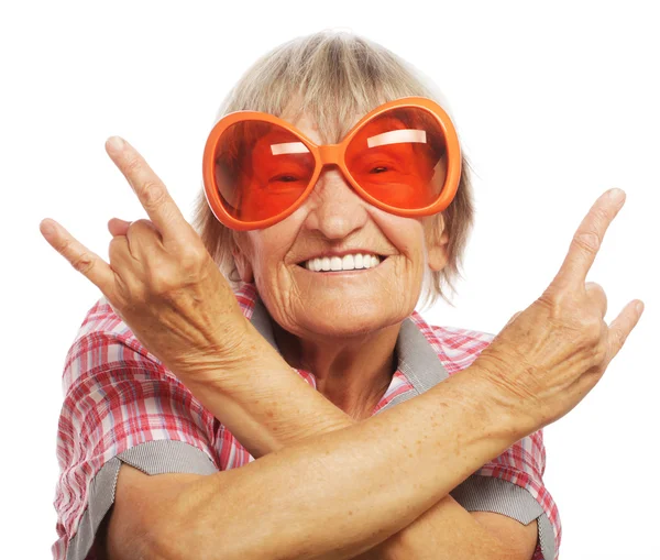 Ανώτερος γυναίκα, φορώντας μεγάλα γυαλιά ηλίου, κάνει funky ενέργεια απομονωμένες — Φωτογραφία Αρχείου