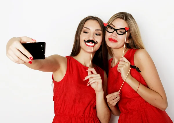 Duas jovens mulheres vestindo vestido vermelho tomando selfie — Fotografia de Stock