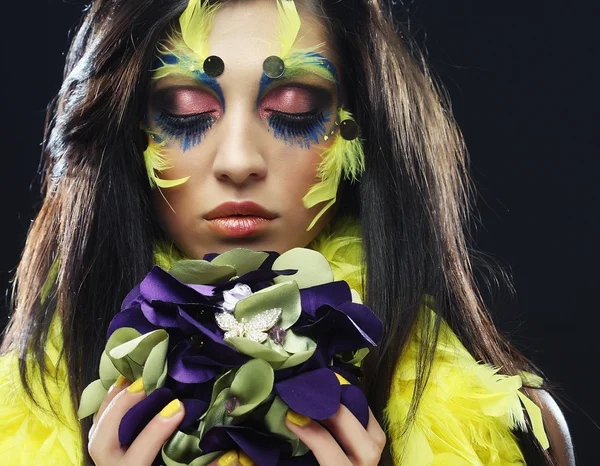 Kvinna med kreativ make up hålla en bukett smycken — Stockfoto