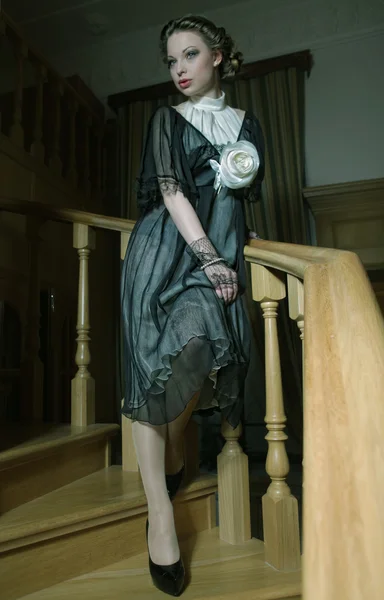 Frau in elegantem Kleid posiert auf Treppe — Stockfoto