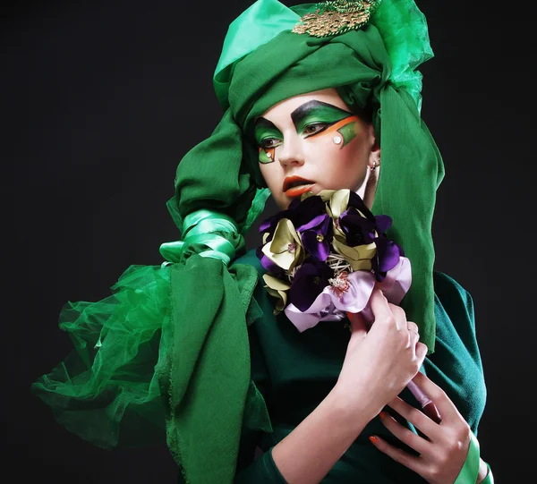 Femme avec maquillage créatif tenant un bouquet de bijoux — Photo
