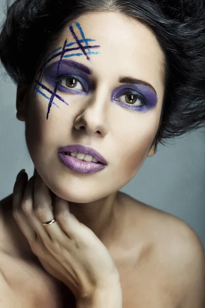 Unga kvinnliga ansikte med ljusa mode mångfärgade make-up — Stockfoto