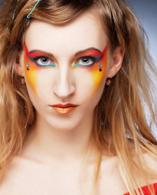 Yaratıcı görünüşlü bir kızın yüzüne yaklaş.