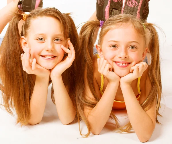 Duas meninas bonitas que colocam no branco — Fotografia de Stock