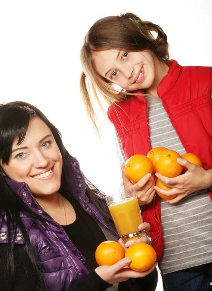 Child with mother holding oranges and juice Royalty Free Stock Photos