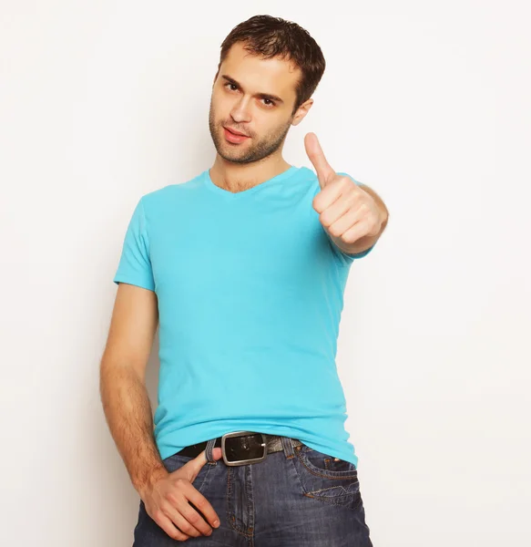 Feliz joven mostrando los pulgares hacia arriba — Foto de Stock