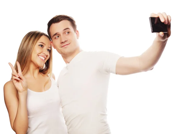 Χαμογελώντας ζευγάρι με smartphoneτεχνολογίας, της αγάπης και της φιλίας έννοια - χαμογελώντας ζευγάρι με smartphone, selfie και διασκέδαση. στούντιο πυροβόλησε πάνω από το λευκό φόντο — Φωτογραφία Αρχείου