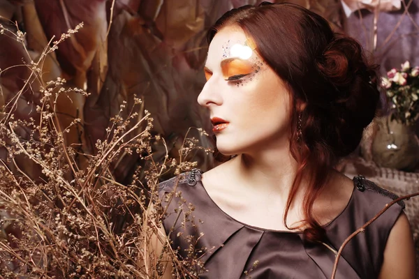 Žena s jasným make-up se suchými větvemi — Stock fotografie