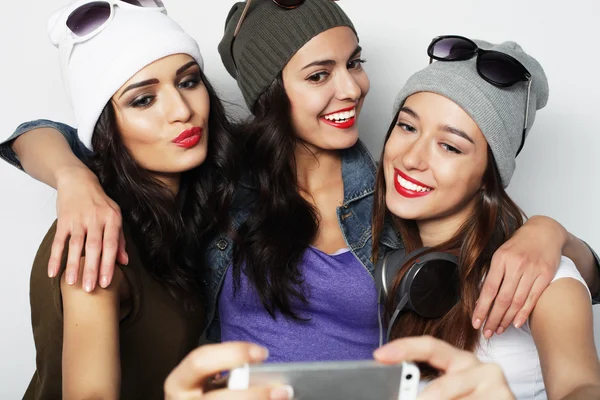 Tre glada tonårsflickor med smartphone med selfie — Stockfoto