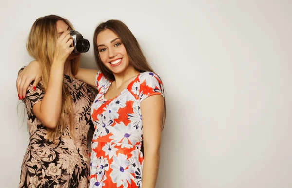 Felice ragazze amiche scattare alcune foto, su sfondo grigio — Foto Stock