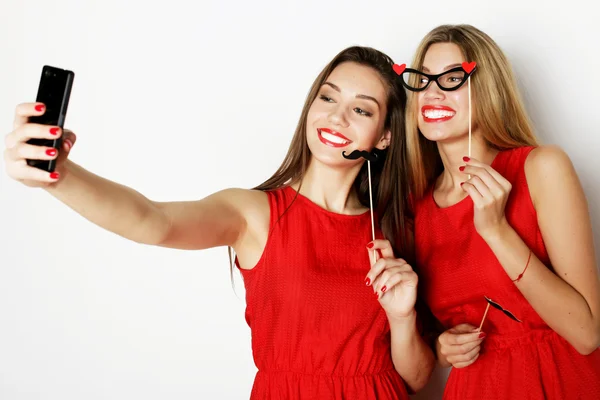 Kırmızı elbiseli iki genç kadın selfie çekiyor. — Stok fotoğraf