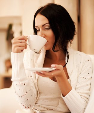 bir kupa kahve tutan kadın