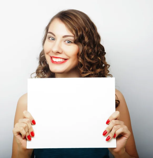 Sonriente joven mujer estilo casual mostrando letrero en blanco — Foto de Stock