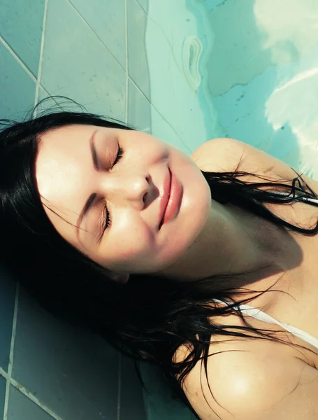 Young woman smiling in a swimming pool — Stock Photo, Image