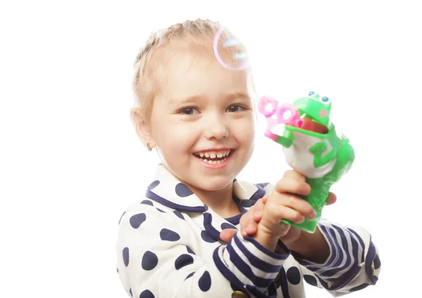 Kleines Mädchen pustet Seifenblasen — Stockfoto