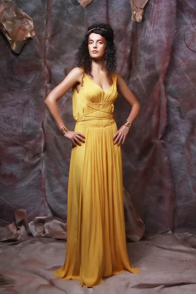 Brunette woman wearing yellow evening dress — Stock Photo, Image