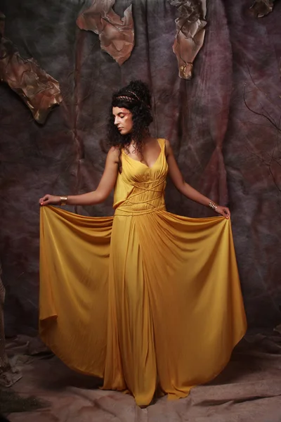 Mulher morena usando vestido de noite amarelo — Fotografia de Stock