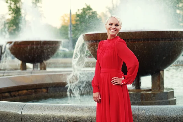 Modische junge blonde Frau trägt rotes Kleid — Stockfoto