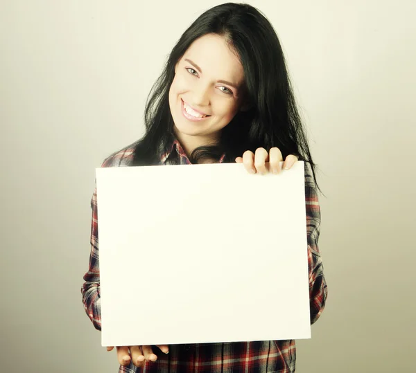 Sonriente joven mujer estilo casual mostrando letrero en blanco — Foto de Stock