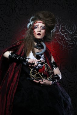 Kırmızı bir yağmurluk içinde yaratıcı makyaj ile genç kadın