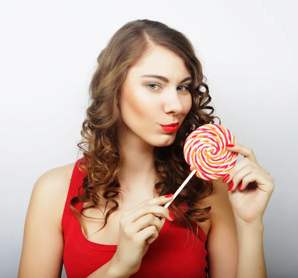 Portrait of a smiling cute girl covering her lips with lollipop — Stock Photo, Image