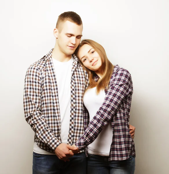 Encantadora pareja feliz abrazándose sobre fondo gris . —  Fotos de Stock