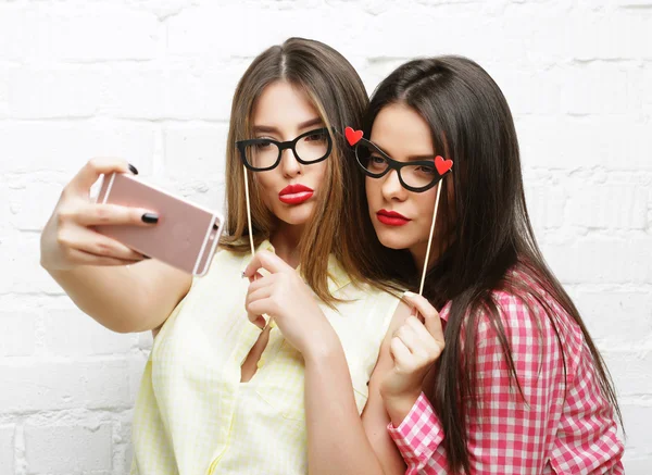 Duas jovens mulheres com óculos de festa tomando selfie — Fotografia de Stock