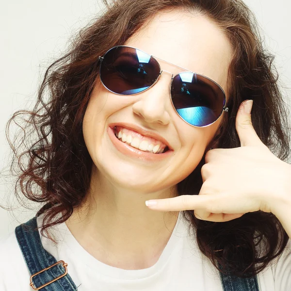 Femme avec des lunettes de soleil faire un appel moi geste — Photo