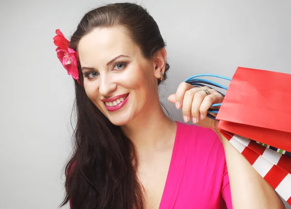 Porträtt av ung glad leende kvinna med shoppingväskor — Stockfoto