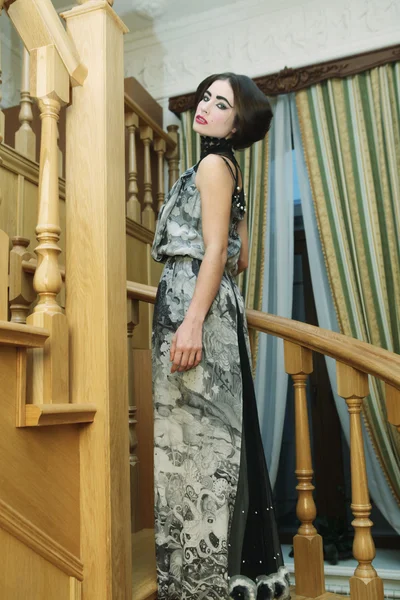 Woman in elegant dress posing on stairs — Stock Photo, Image