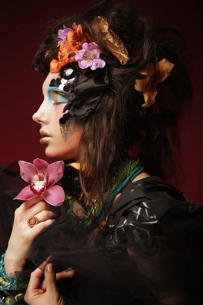 Mujer con maquillaje creativo sosteniendo flor rosa —  Fotos de Stock